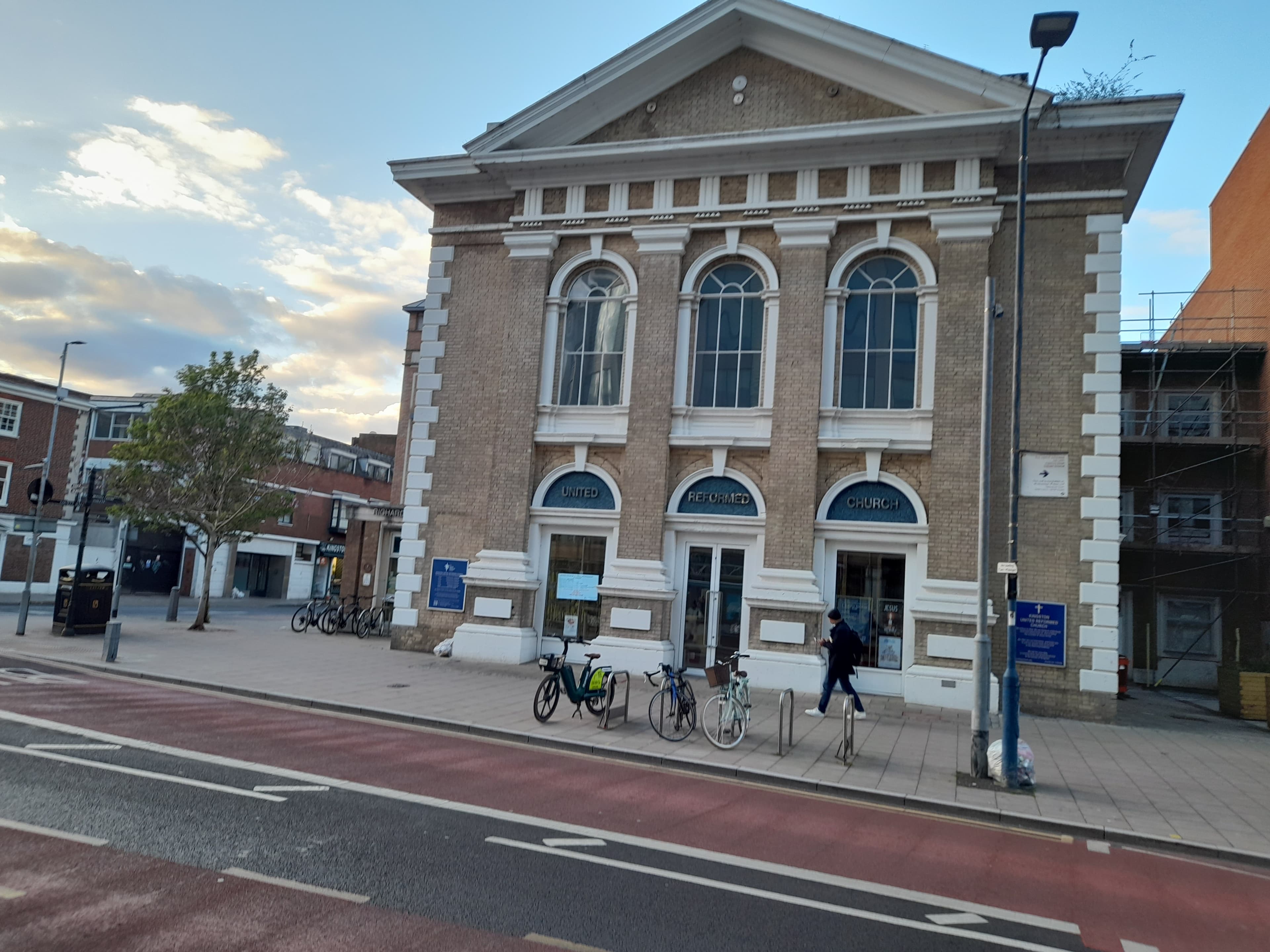 Neoclassical brick United Reformed Church with white trim and bicycles parked on the sidewalk.